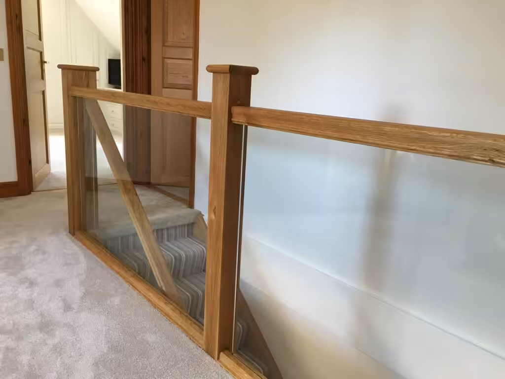 landing view of staircase in oak with tough safety glass manufactured by one stop joinery