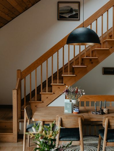 wooden table sitting under a stair case